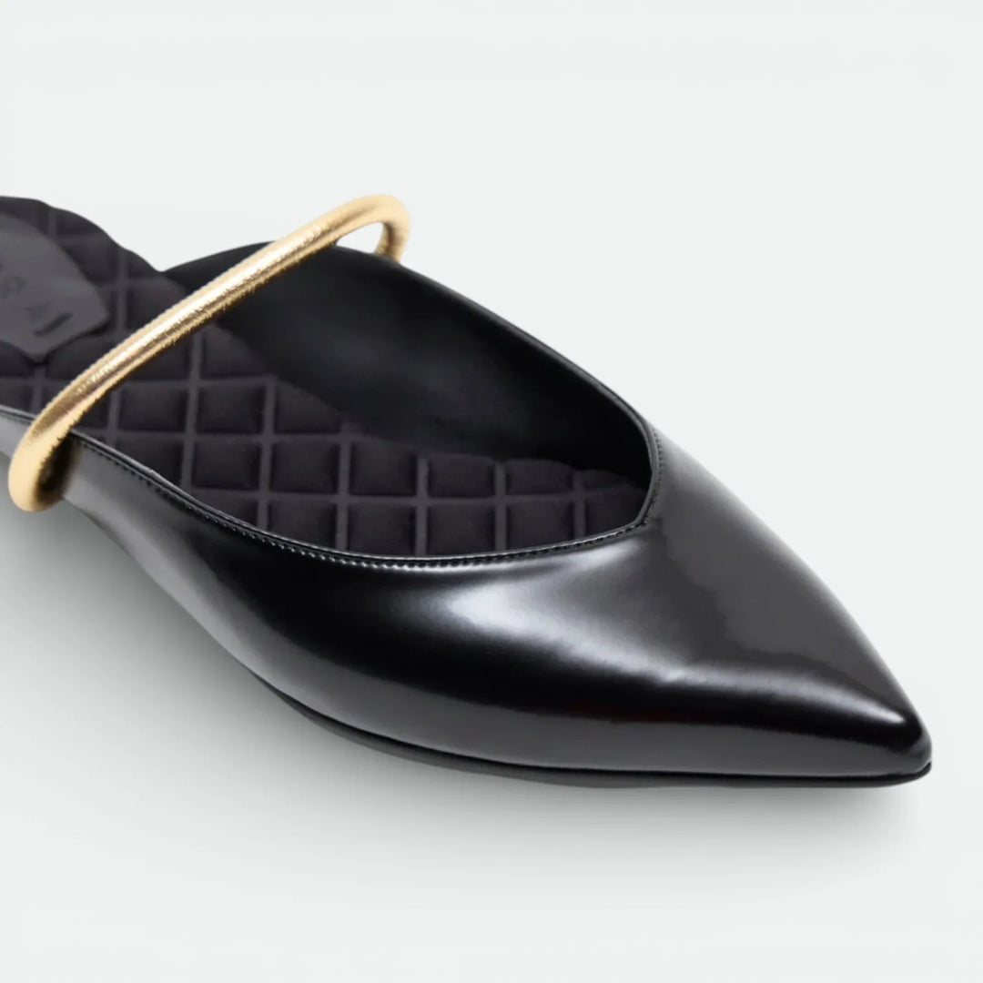 Pointed toe black leather flat shoe with a gold accent band and quilted insole