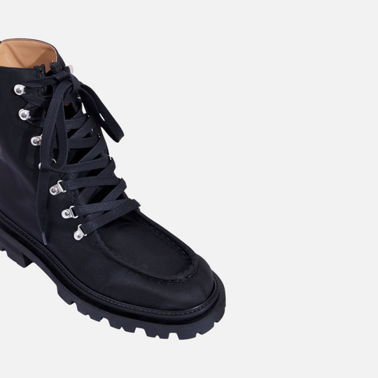 AERA AMALIA black lace-up ankle boot, front three-quarter view of the laces, metal eyelets and lug sole.