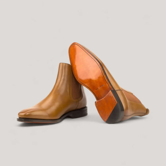 Botines Chelsea de piel box calf color coñac mostrando la suela completa de cuero