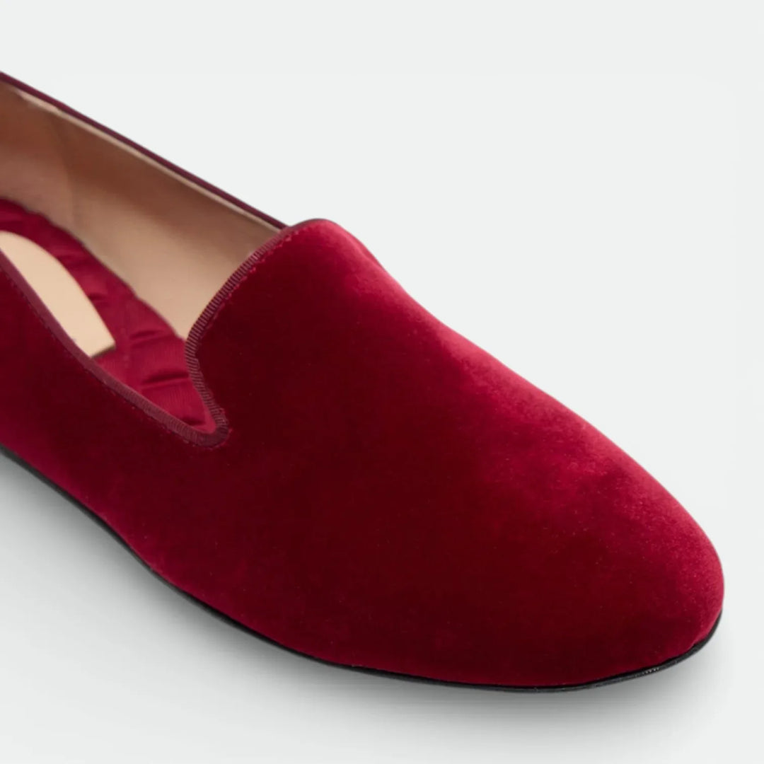 Crimson red velvet loafer with almond toe and low heel on a light background