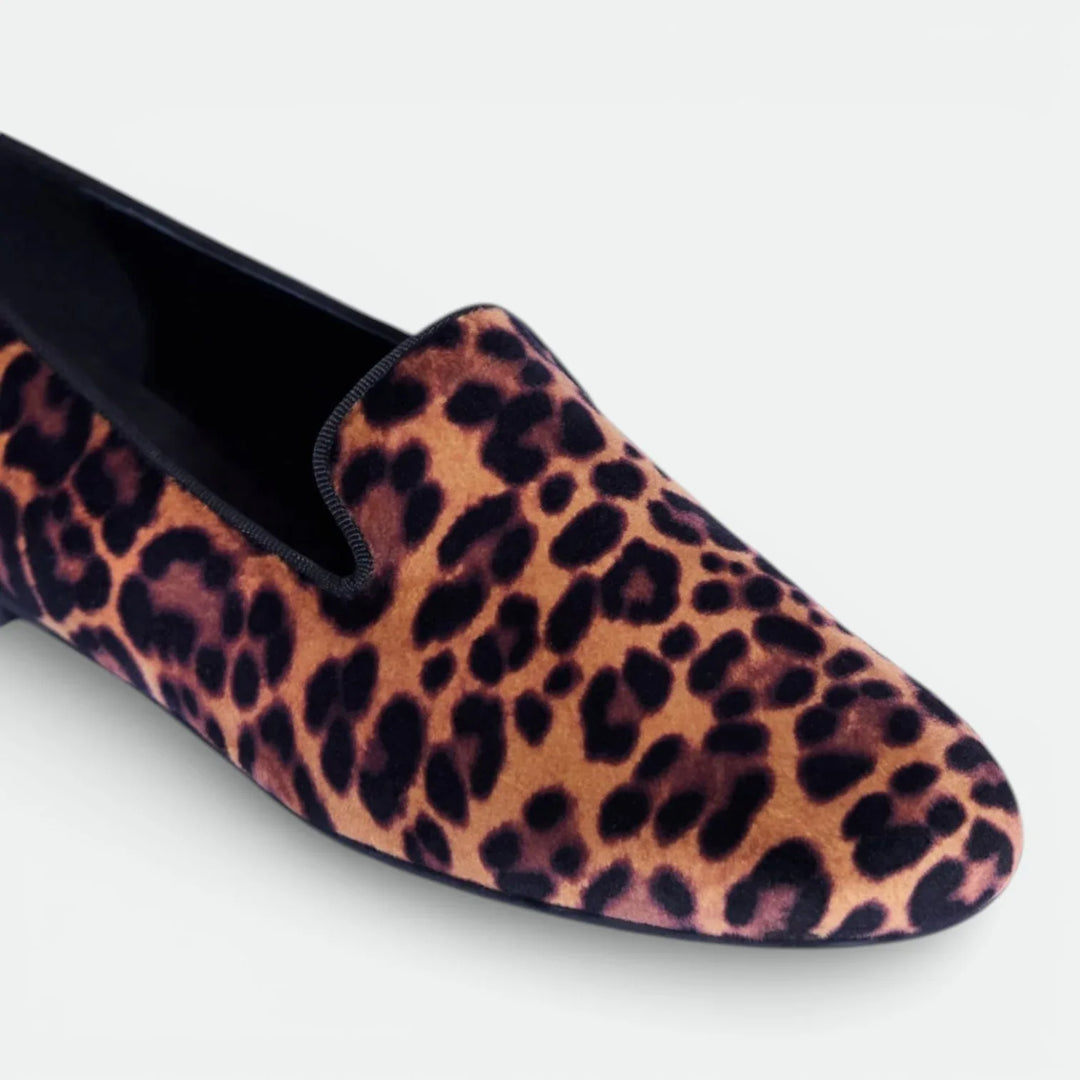 Leopard print velvet loafer shoe with black trim, photographed on white background