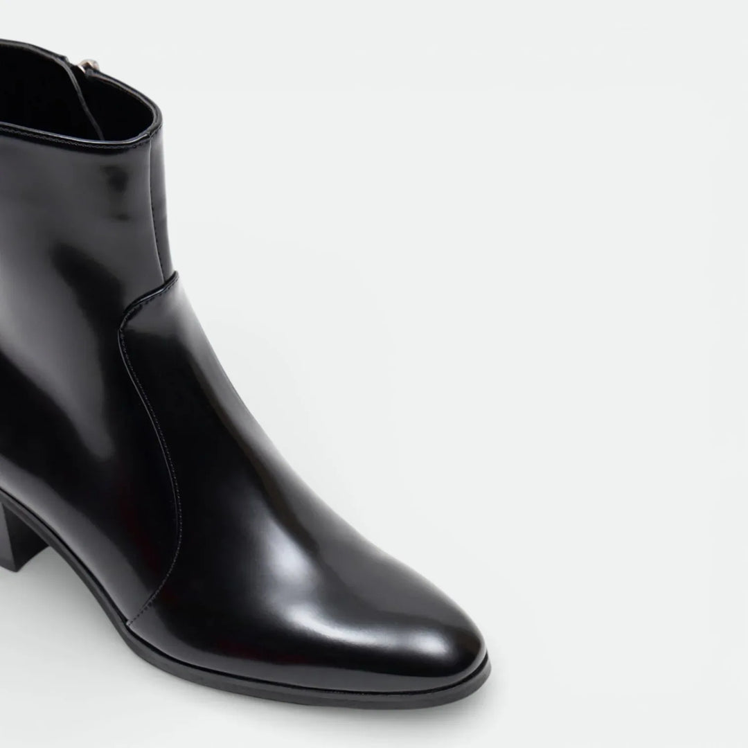 Black leather ankle boot with mid heel and side zipper on white background