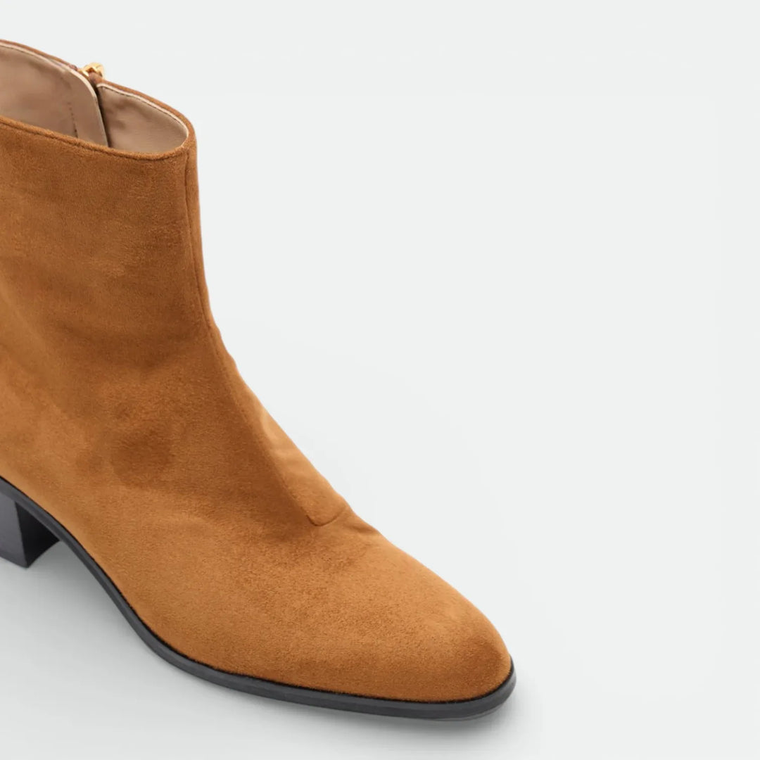 Tan suede ankle boot with low block heel and side zipper on white background